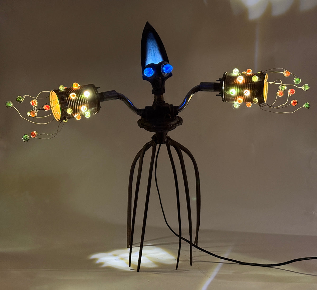 Scuttletron original alien robot lamp by Bobby Anderson with glowing marble lights, pitchfork legs, and reclaimed metal parts