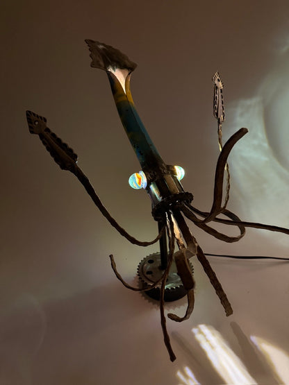 Illuminated Squid sculptural lamp casting underwater-style shadows through reclaimed metal