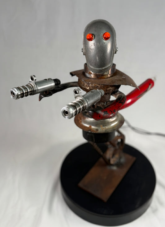 Artistic robot sculpture with red eyes on a white background