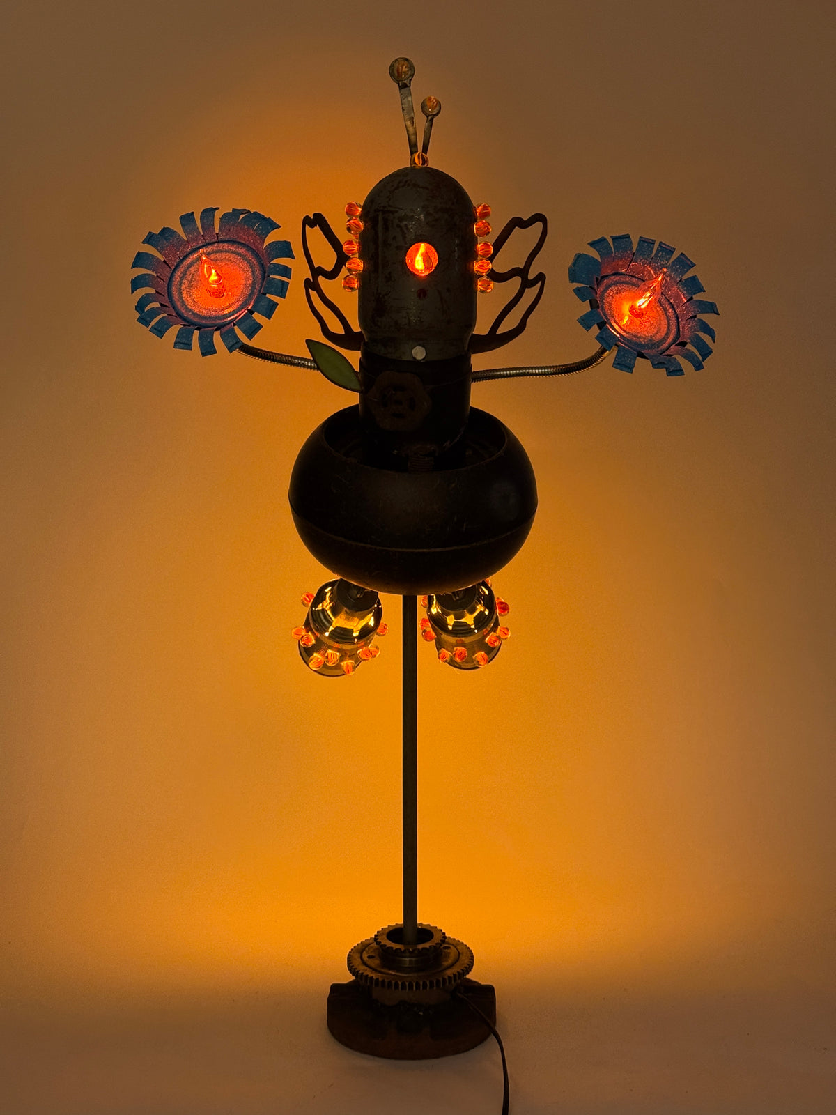 Firefly original sculptural robot lamp by Bobby Anderson with illuminated flower hands, glowing glass marbles, and reclaimed metal wings