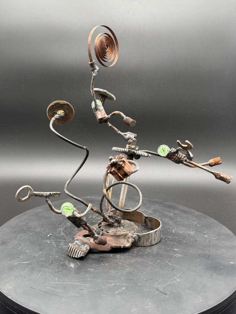 Calamity original reclaimed metal sculpture by Bobby Anderson featuring three robot figures caught in a mechanical accident