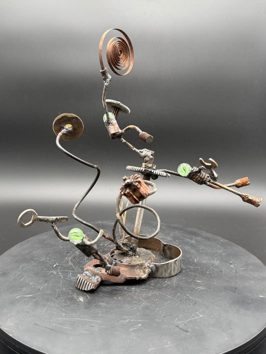 Calamity original reclaimed metal sculpture by Bobby Anderson featuring three robot figures caught in a mechanical accident