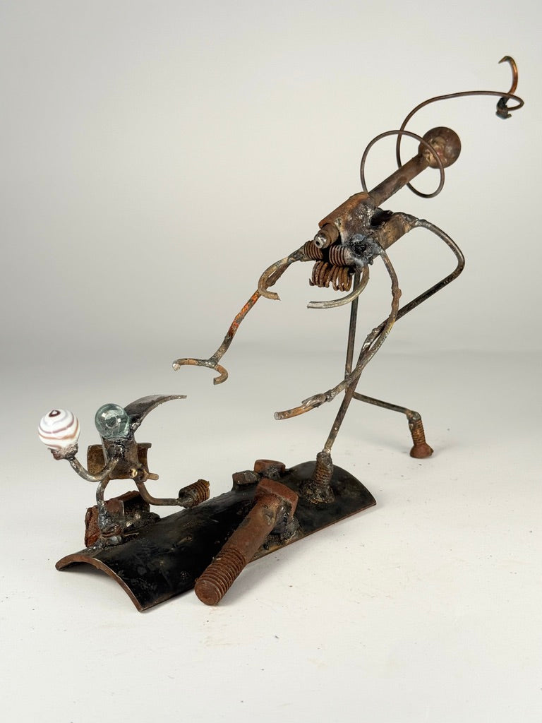 Egg Thief original reclaimed metal sculpture by Bobby Anderson showing a small thief escaping with a monster egg while a creature gives chase