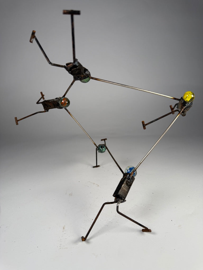 We Got This original reclaimed metal sculpture by Bobby Anderson featuring five interconnected figures with glass marble heads