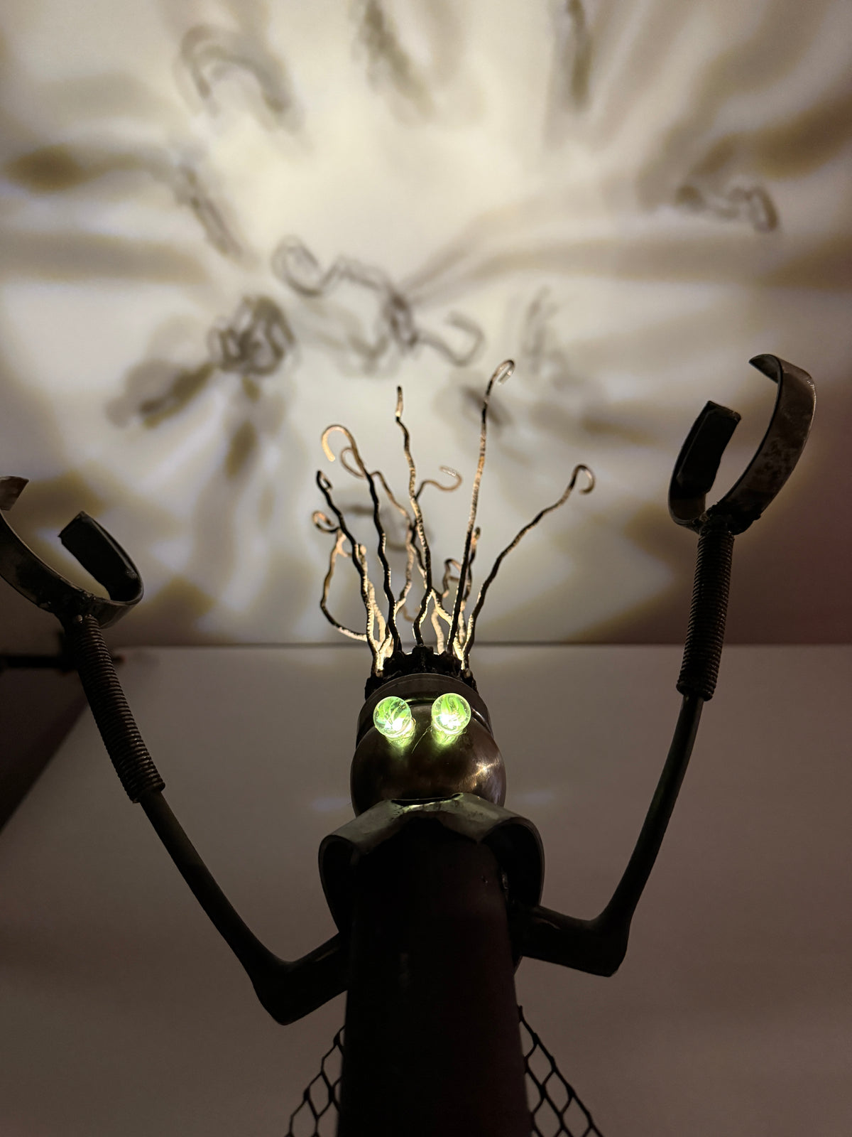 Kahuna original sculptural robot lamp by Bobby Anderson with magnetized hands, iron mesh cape, and projected ceiling light