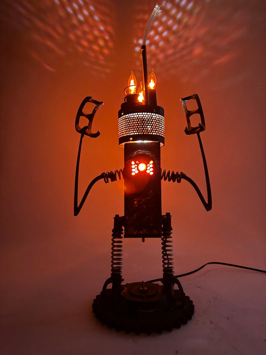 Hangry original sculptural lighting by Bobby Anderson with spring-loaded arms and legs, flickering bulbs, and glowing reclaimed metal body